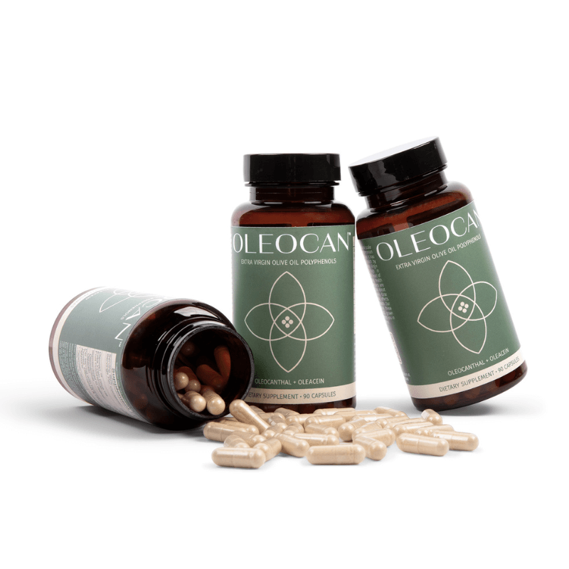 Three OLEOCAN™ Capsules bottles with green labels—two upright, one tipped over with beige capsules spilling out—are shown. Each offers a 90-day supply of premium EVOO polyphenol supplement inspired by the Mediterranean diet.